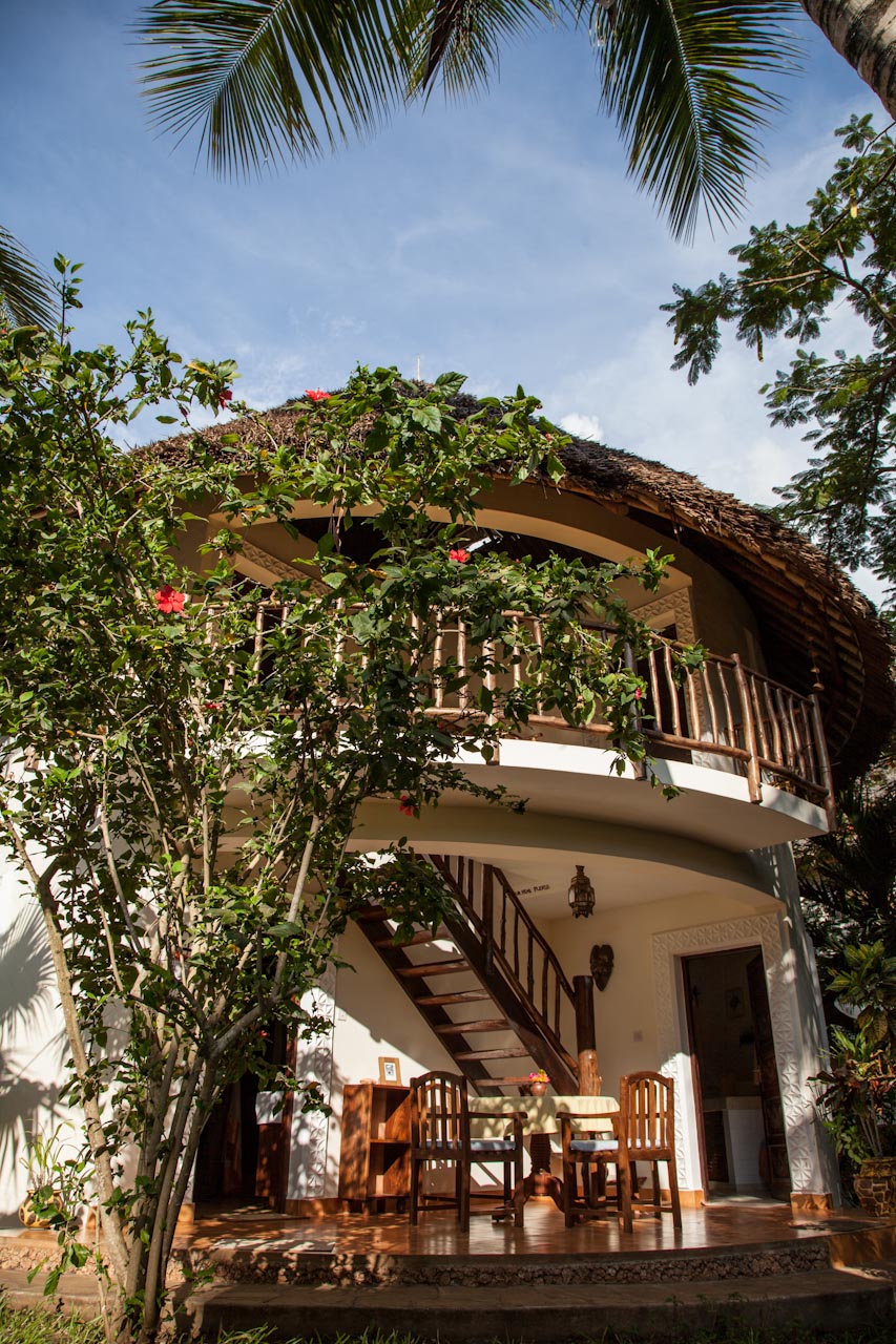 Villa cottage exterior with hibiscus and wooden staircase